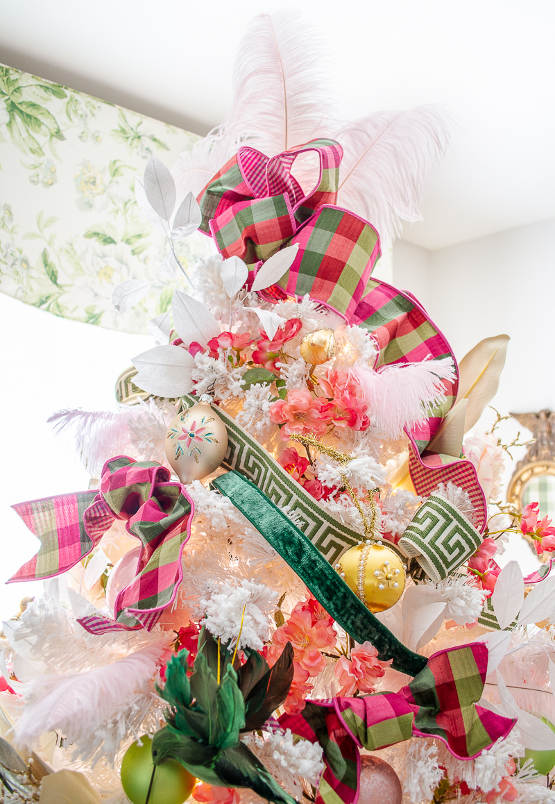 A pink and green plaid bow and pink ostrich feathers top this very Chinoiserie Christmas tree
