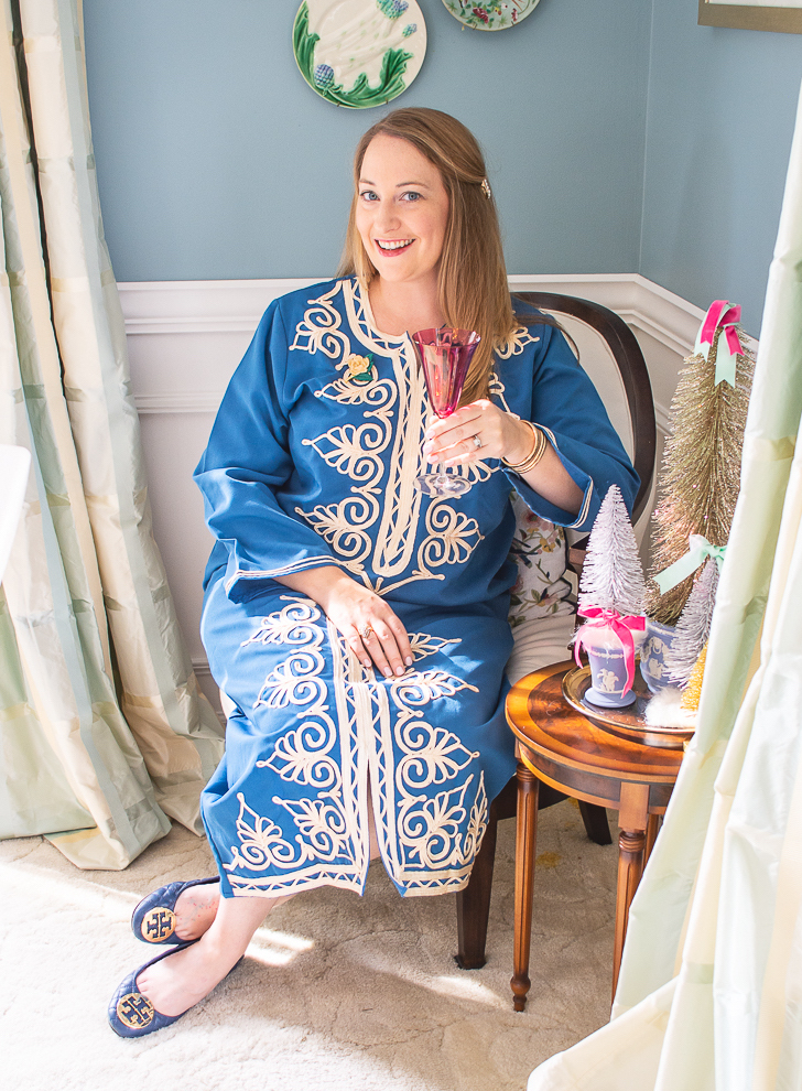 Katherine in blue caftan toasting a Merry Christmas