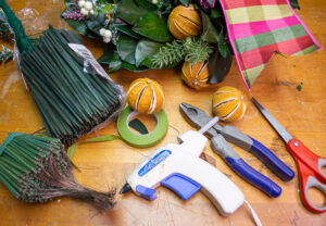 Tools and supplies needed to make Christmas wreaths with dried citrus