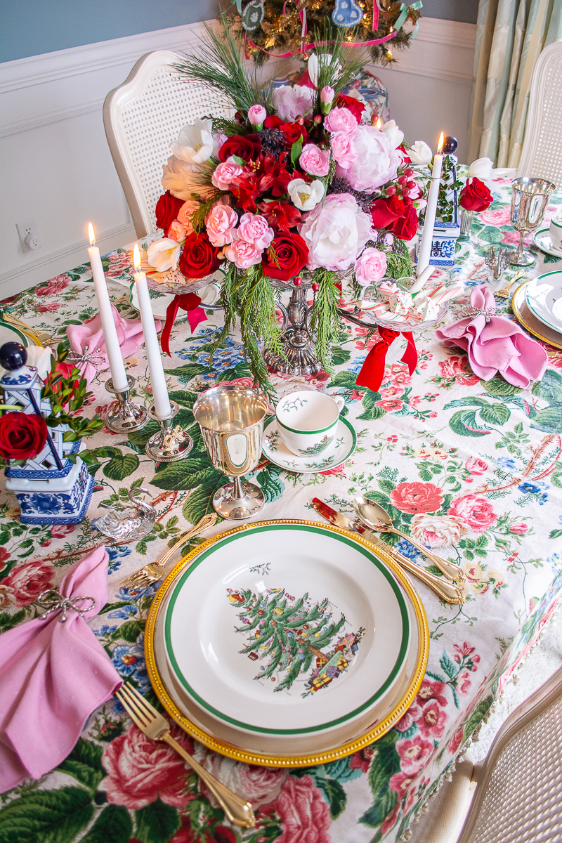 Spode Christmas Tree china on silver chargers with pink napkins and chintz tablecloth decorate this grandmillennial Christmas table