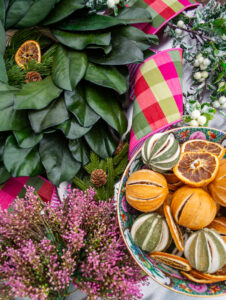 Floral and greenery materials for Williamsburg inspired magnolia & citrus Christmas wreath laid out on table