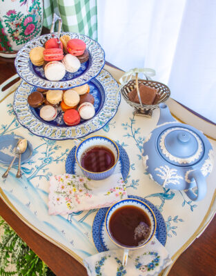 delightful winter tea setup with blue and white teacups, Wedgwood teapot, macrons, chocolate biscuits, and black tea