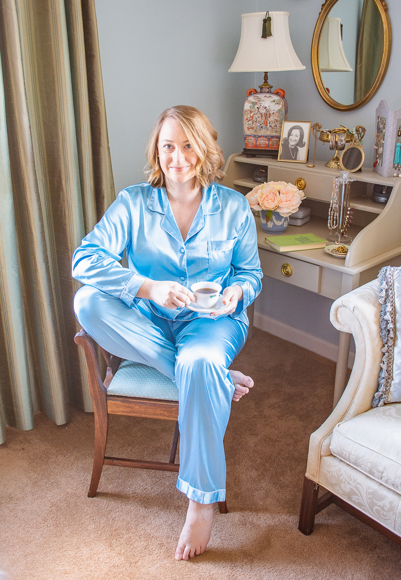 Katherine sitting on vanity bench in pretty loungewear of matching set of aqua pajamas