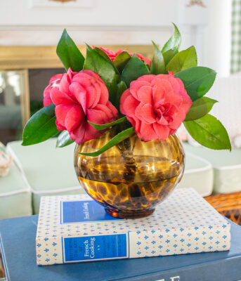 Tortoise shell glass vase filled with pink camellias