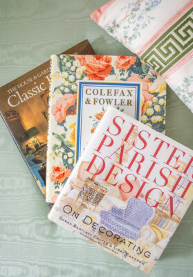 Stack of design books on traditional designers: Sister Parish, Colefax & Fowler, and Classic Interiors