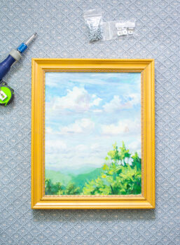 How to frame a painting with offset clips - finished landscape painting in gold frame.
