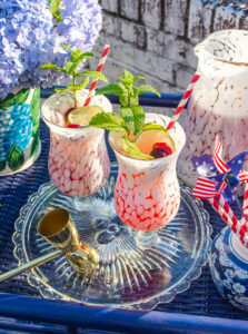 Cherry mint lemonade cocktails on navy bar cart decorated for the 4th of July