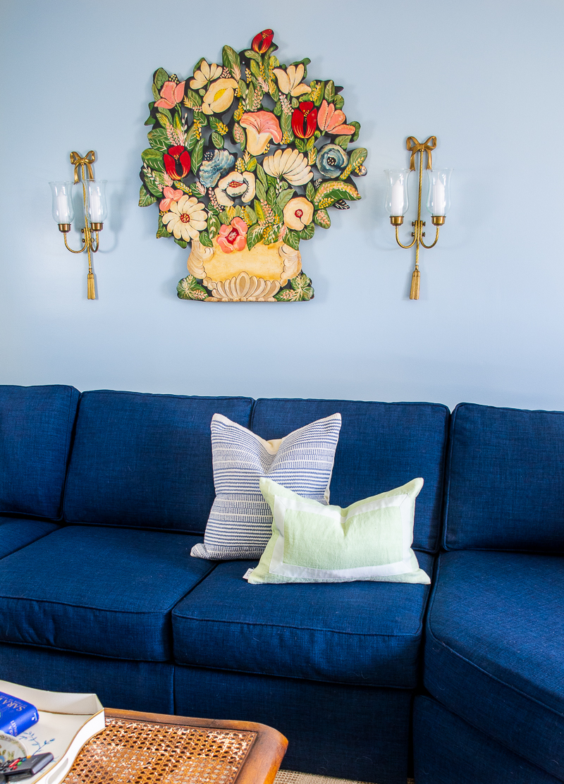 Navy section in blue and white family room with toleware art, stripe pillows, and bow sconces