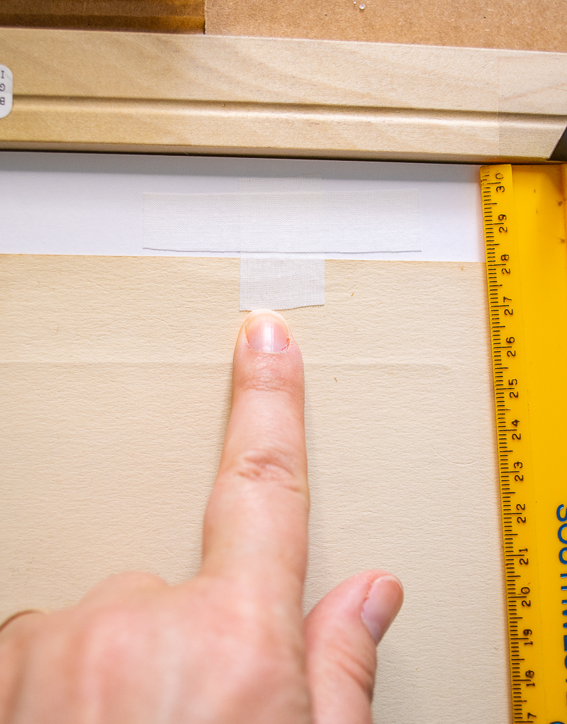 Create "T" shaped hinge with acid free tape to secure print to mat