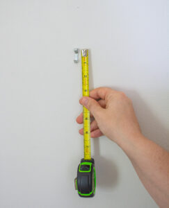 Katherine shows the 1 inch drop between the nail and hanging hook