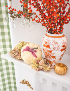 Small white pumpkin tied with pink velvet bow and nestled in preserved hydrangea