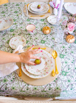 Katherine places fig on plates for autumn themed tablescape in pink and green