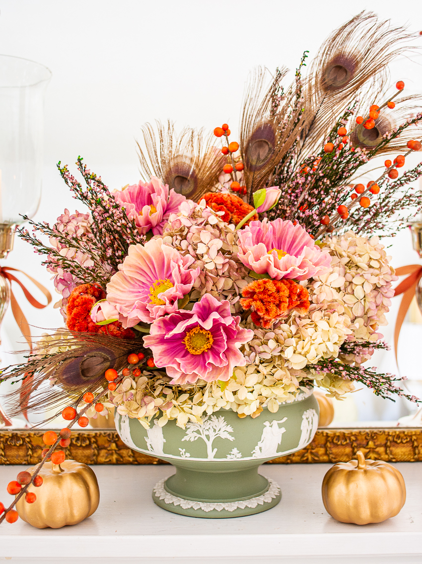 Dried hydrangea, peacock feathers, purple poppies, and orange berries fill this antique Wedgwood Jasperware compote for an elegant floral arrangement for autumn