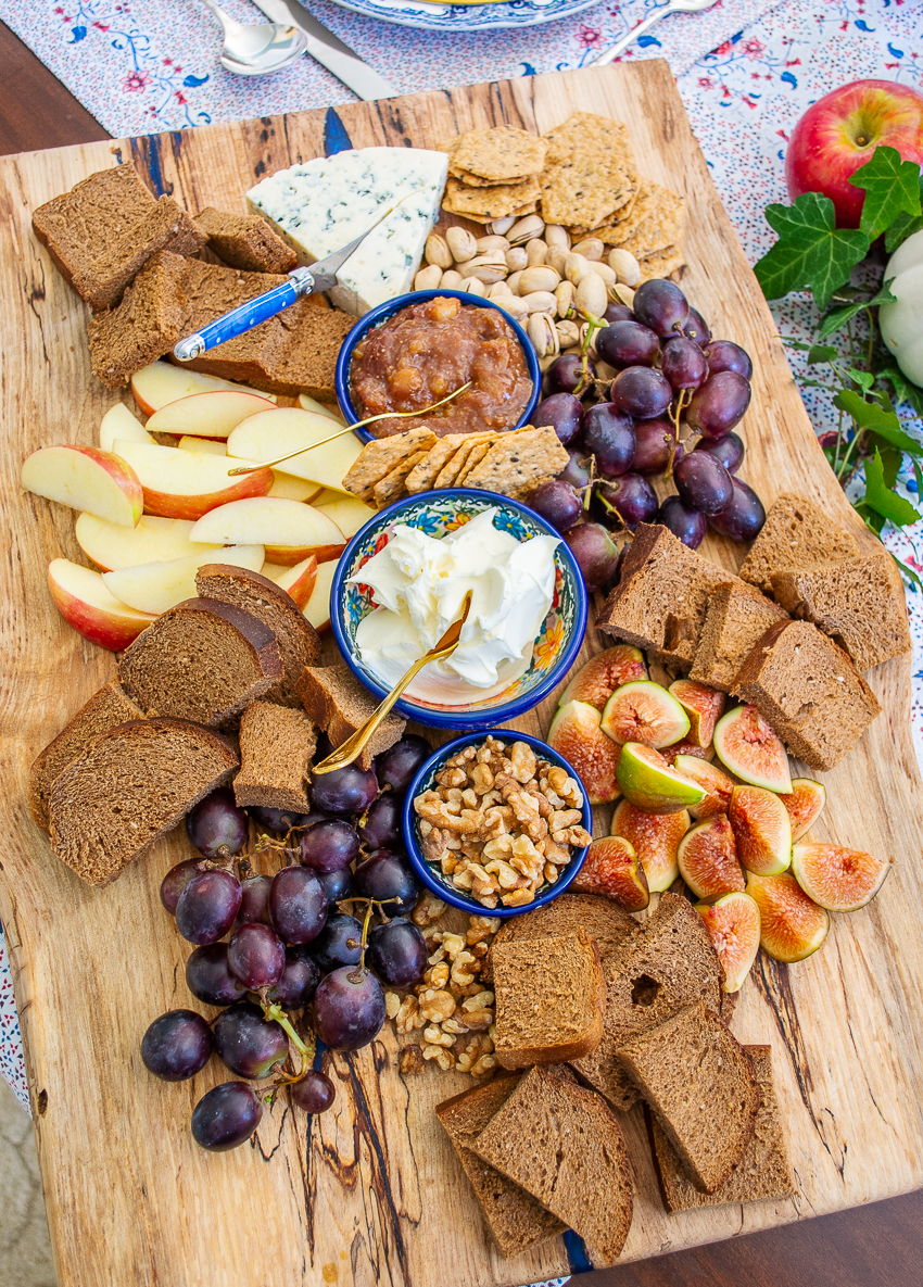 Autumn cheese board with figs, grapes, apples, and marscapone