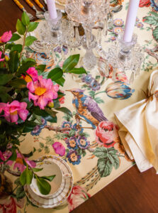 Vintage chintz with fanciful birds and blossoms runs down the center if the table. Fabric is labeled Texoprint 819-20957