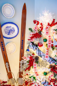 Detail view of white Christmas tree with vintage skiis propped up beside it