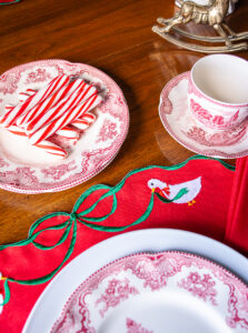 detail of green and red vintage placemats with bow detail and little white geese