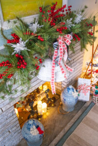 top view of faux pine swag on mantel with white tin bells