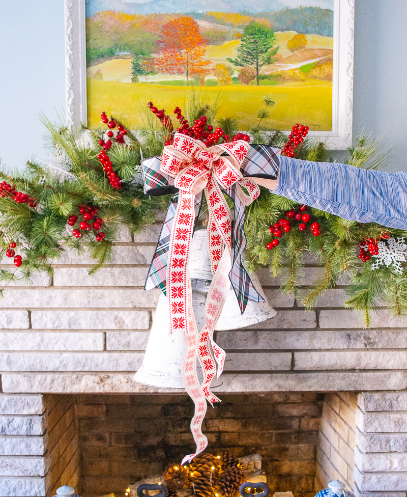 snowflake and plaid bow for center of pine swag on cozy Christmas mantel