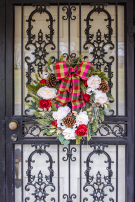 Take a simple mixed evergreen wreath from Target and transform it with white and red blooms, plaid ribbon, branches, and gold leaves for a festive bespoke Christmas wreath