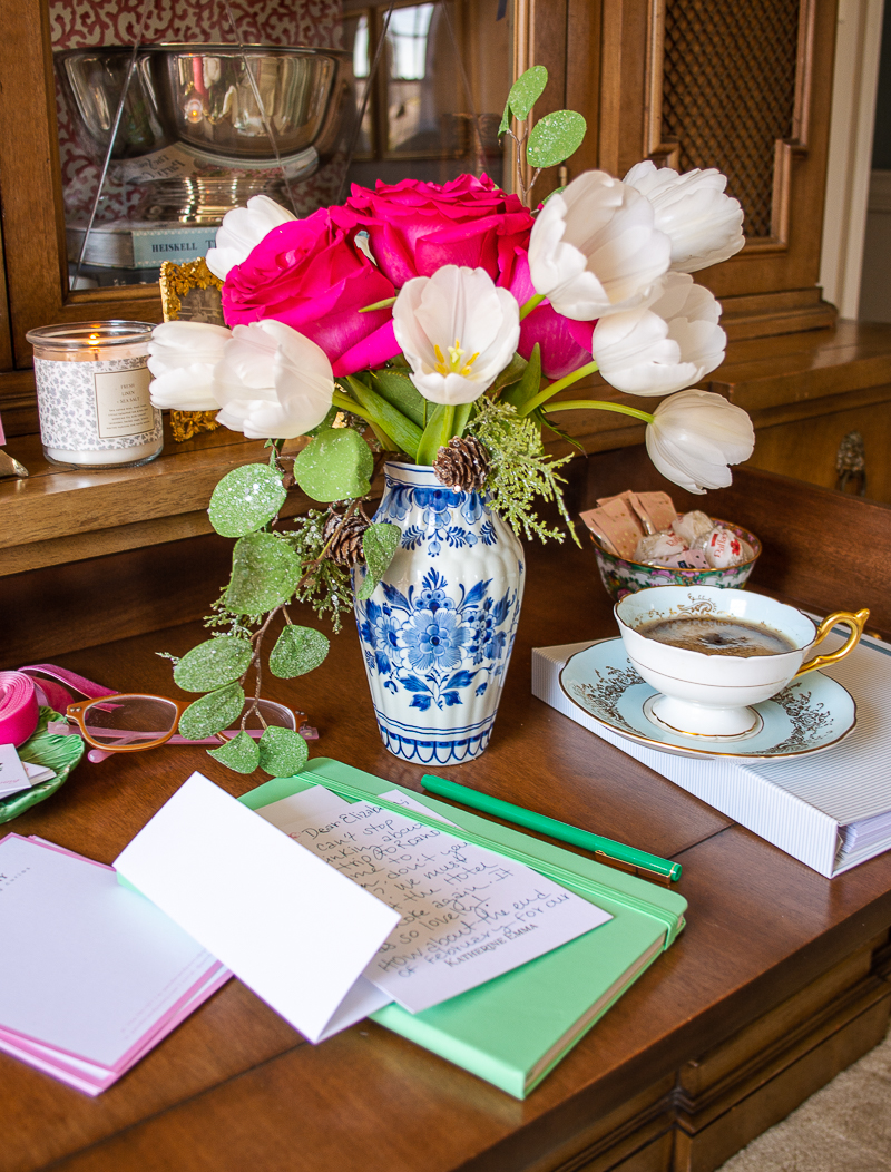 Katherine's bookcase desk set up for writing handwritten notes with fresh bouquet of flower, coffee, and elegant stationery from Basic Invite