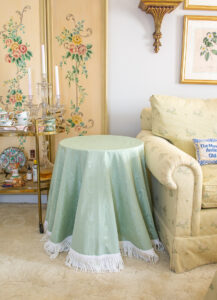 green moire table skirt with white bullion fringe on Ikea metal table