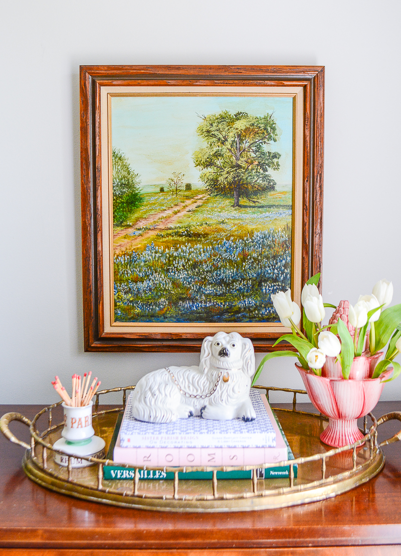 Painting of Texas bluebells hung on wall with Staffordshire style spaniel and pink tulipere arranged underneath