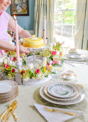 Katherine sets down lemon cake as centerpiece surrounded by tulips, roses, and hydrangea in surtout de table