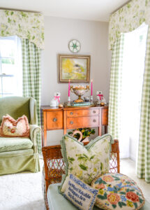My sideboard is decorated with a vintage brass tray, books, hot pink tapered candles, and an antique Rose Medallion ormolu bowl filled with white and copper pumpkins