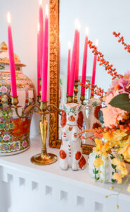 An antique Staffordshire begging spaniel in russet and white adds a unique traditional touch to the autumn decor on the mantel