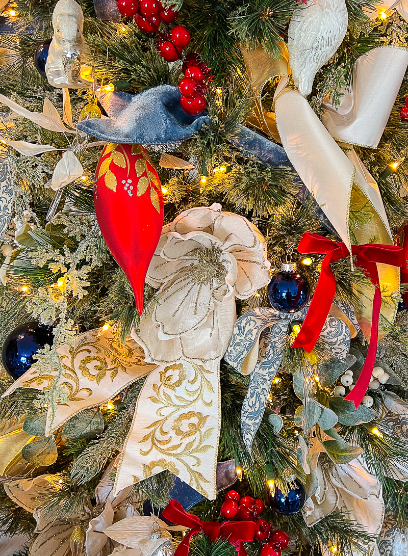 Using a blue and white color scheme for your Christmas tree can be so versatile year after year as you change up small details. Here I paired blue and white ribbon and ornaments with red berries!