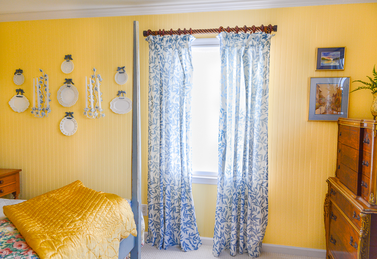 Blue and white leaf patterned curtains from Decoberry hung in a yellow and blue guest bedroom - Katherine discusses her process for choosing bedroom curtains