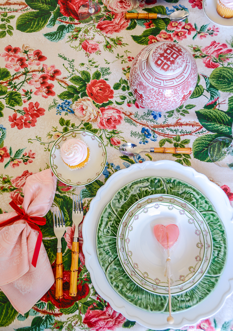 A Grandmillennial place setting with cabbage ware, Limoges china, heart candy, and bamboo flatware set for Valentine's Day
