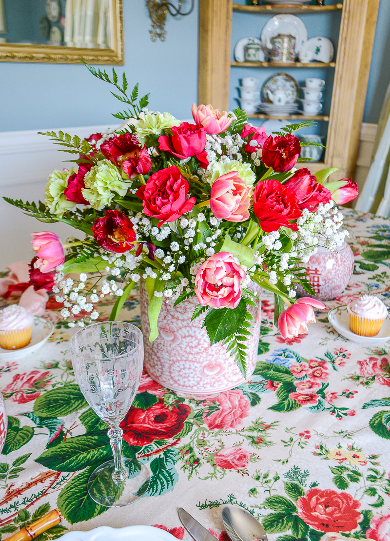 A stunning red, pink, and green floral arrangement in a Chinese peony vase decorates this Grandmillennial Valentine's Tablescape