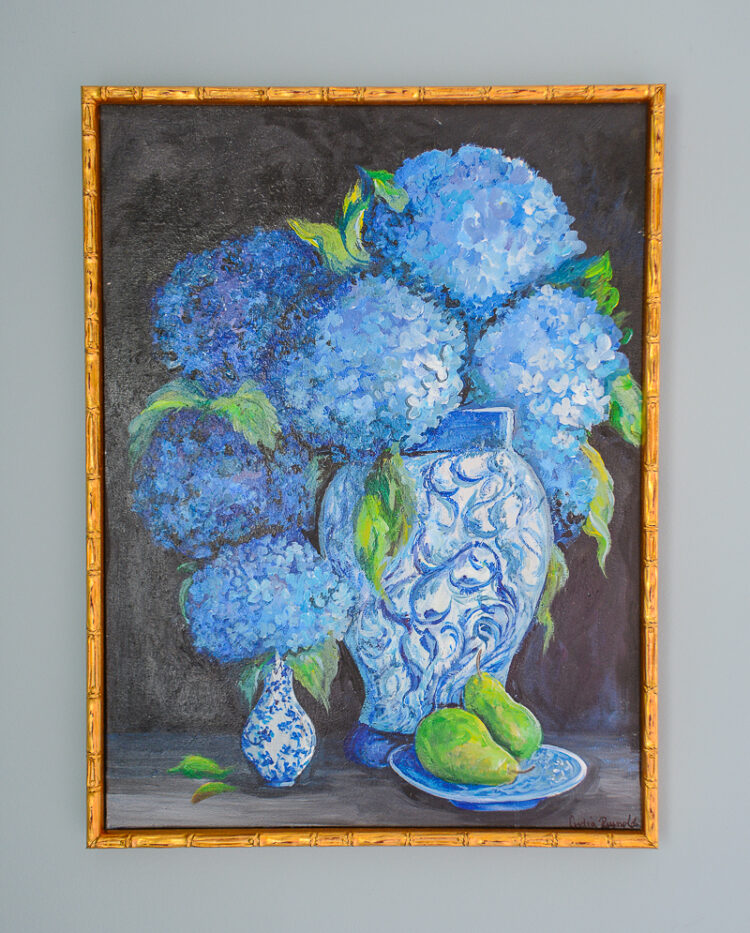 An absolutely stunning painting of hydrangeas in blue and white jars against a dark background with a plate of pears by TN artist Lydia Reynolds.