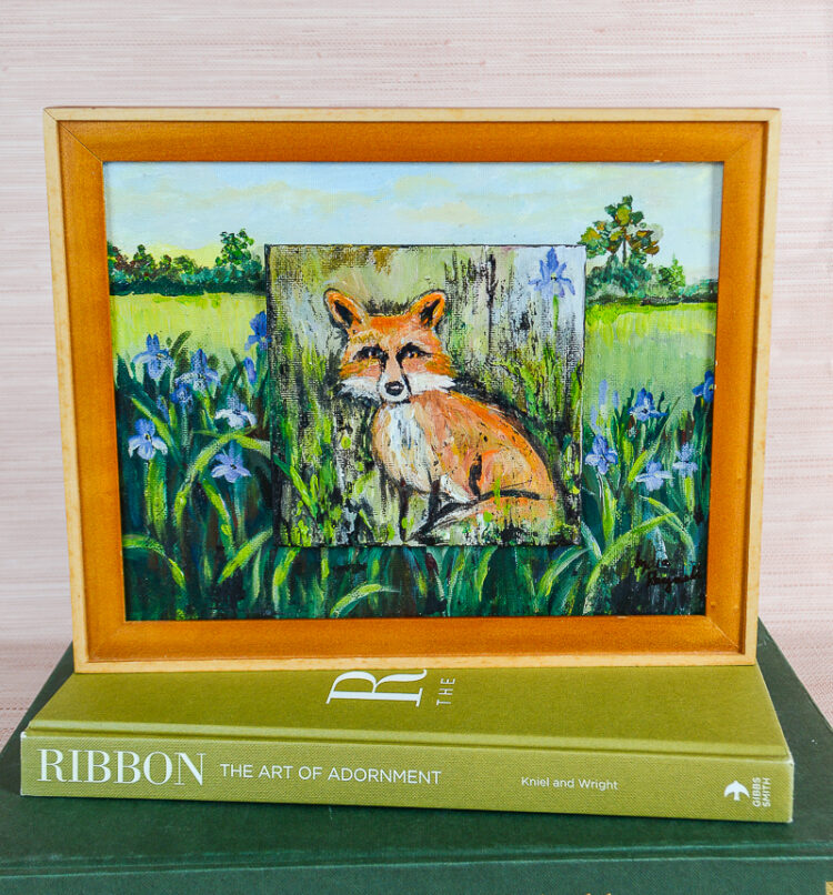 A charming painting of a bold little fox posed amongst a patch of iris by TN artist Lydia Reynolds.