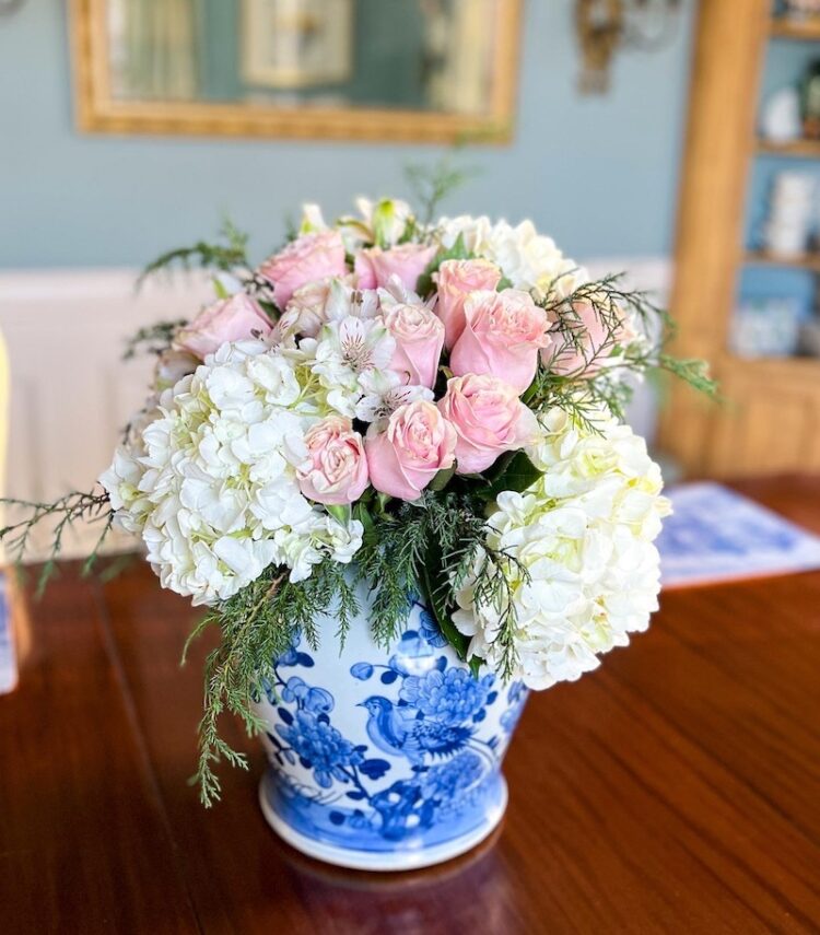 A gorgeous statement Chinese jar in blue and white filled with white hydrangeas and pink roses.