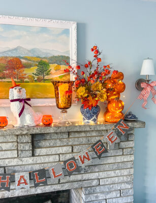 My festive Halloween mantel with a witchy Jane aka my Staffordshire spaniel, jack-o-lanterns, and fall florals