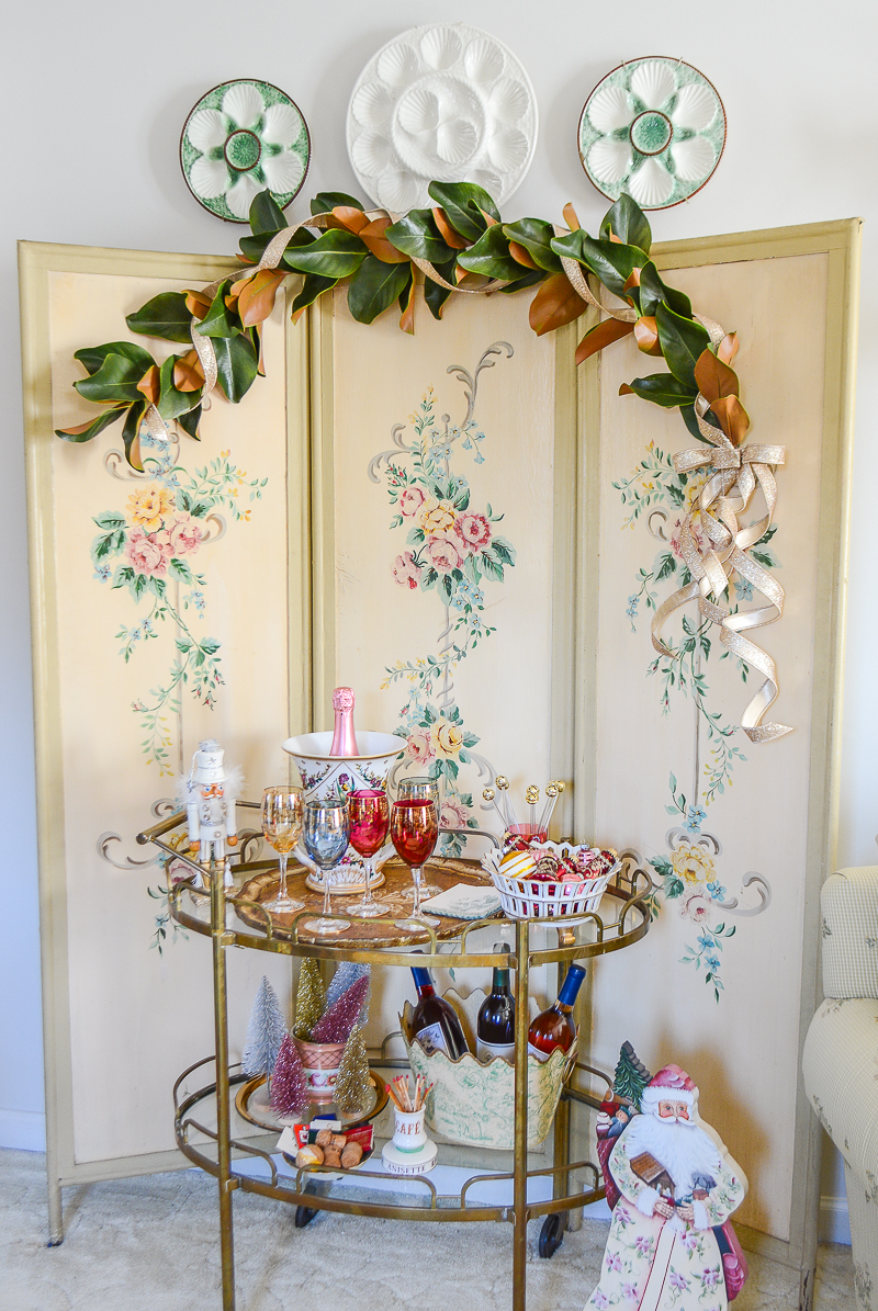 Pink Christmas decor on vintage brass bar cart set up to serve wine