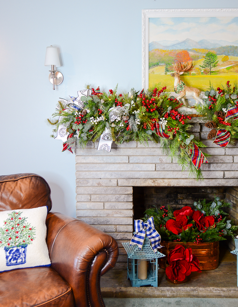 A Fitz & Floyd reindeer centers the sculptural garland display on the mantel