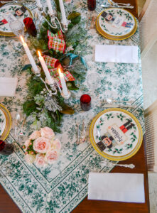 Top view of elegant winter themed Christmas tablescape in green and white with hints of red and pink
