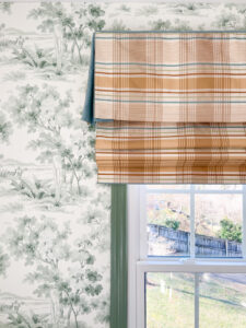 Thibaut plaid roman shade in tans, taupes, blue and green against a green and white toile wallpaper