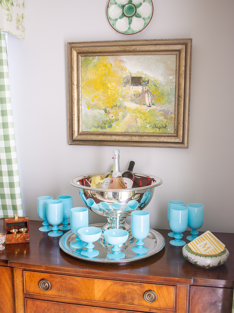 A silverplate punchbowl ices down wine bottles on this sideboard styled as a bar