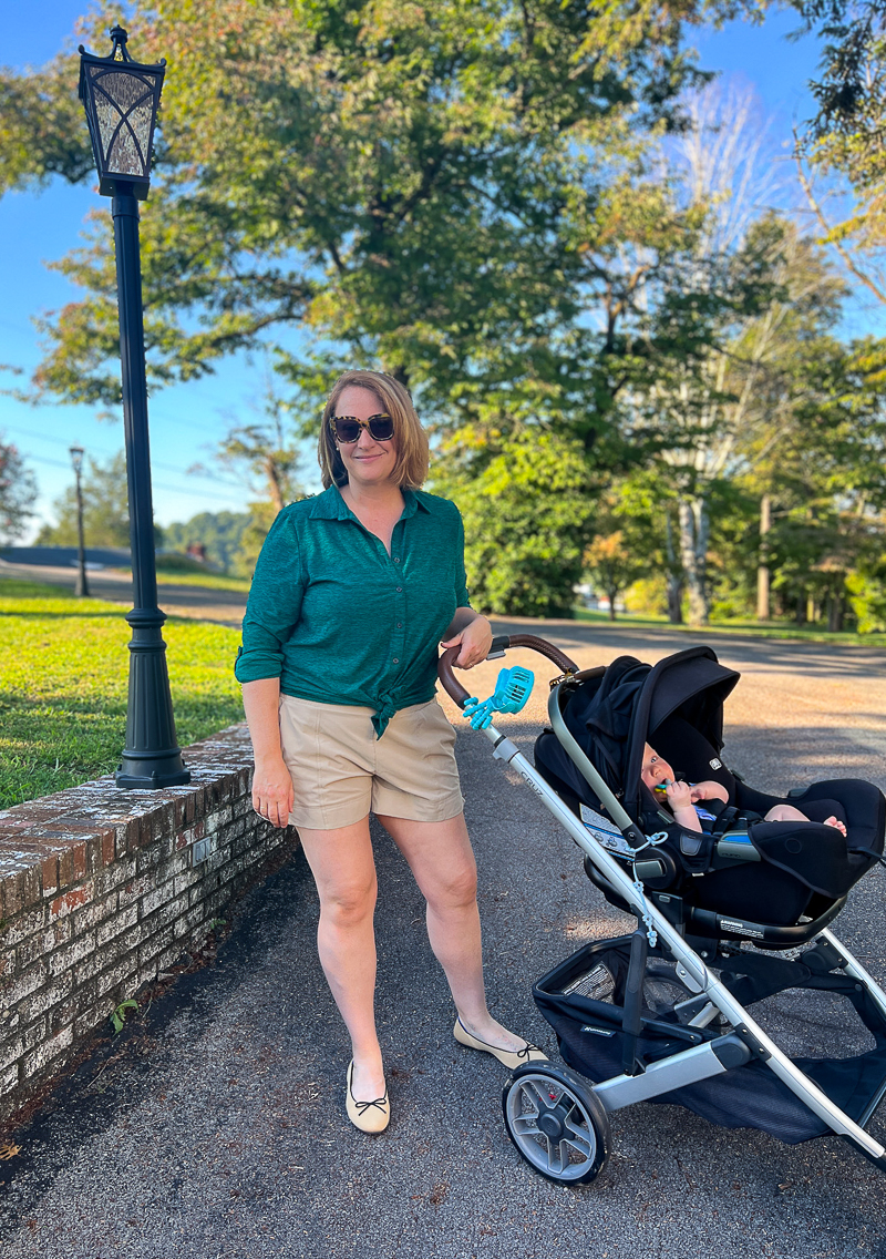 Postpartum necessities to help you thrive during the 4th trimester. Katherine with stroller and baby, wearing LandsEnd tunic and All in Motion shorts