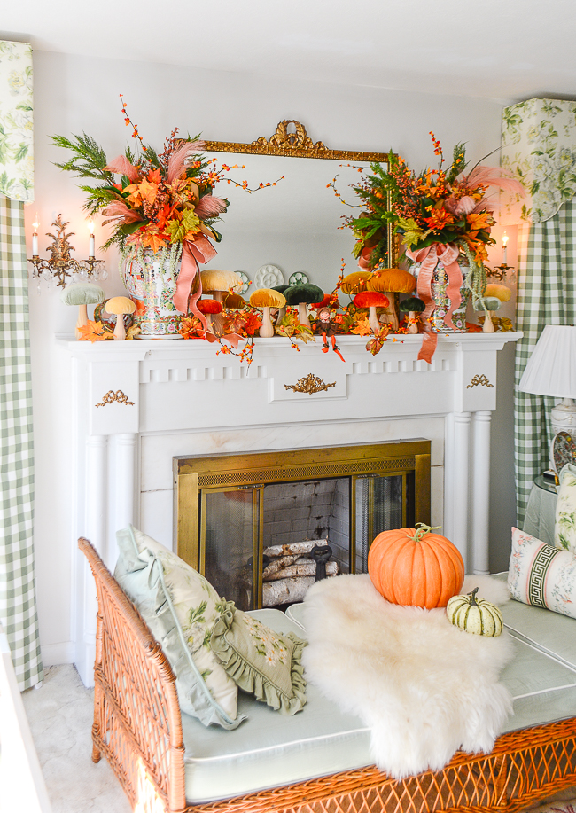 A magical autumn mantel arrangement with velvet mushrooms, Rose Medallion, fall leaves, bittersweet, and whimsical elves