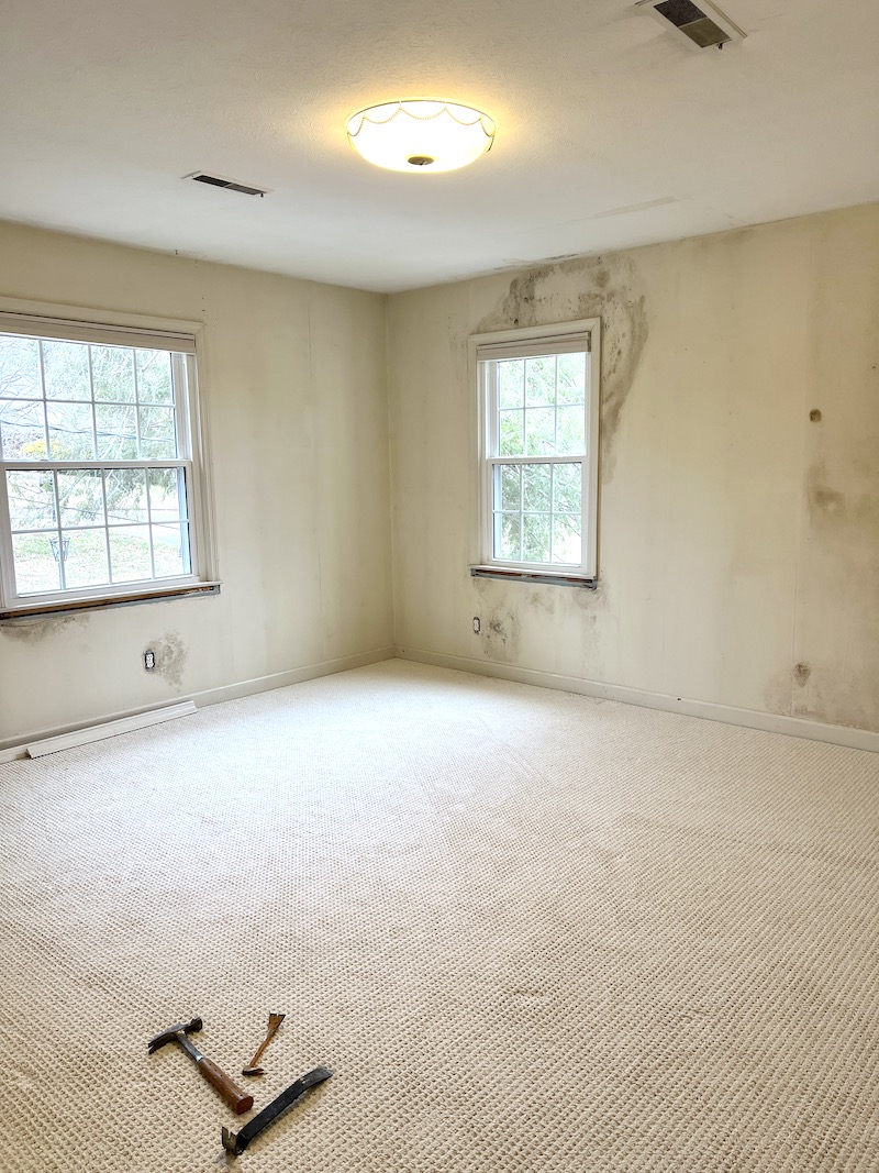 The bedroom all cleared out with wallpaper removed and new carpet down