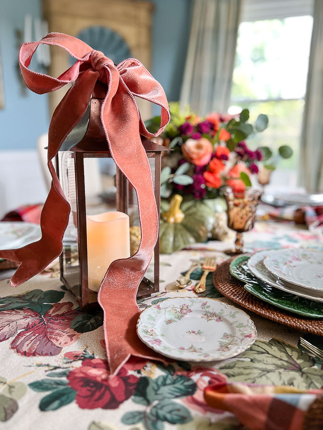 Copper lantern tied with coral velvet bow for festive autumn table decor