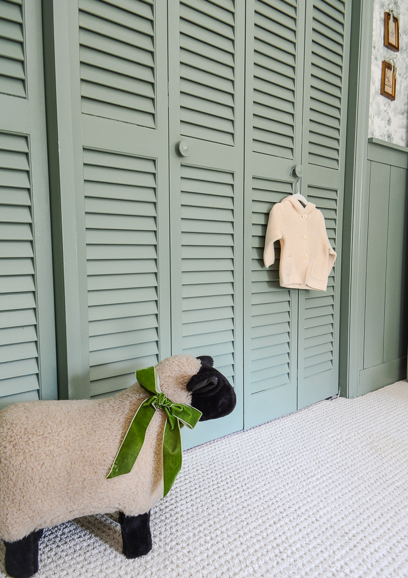 Closet doors painted High Park from Benjamin Moore with vintage sheep footstool and baby's sweater hung on door