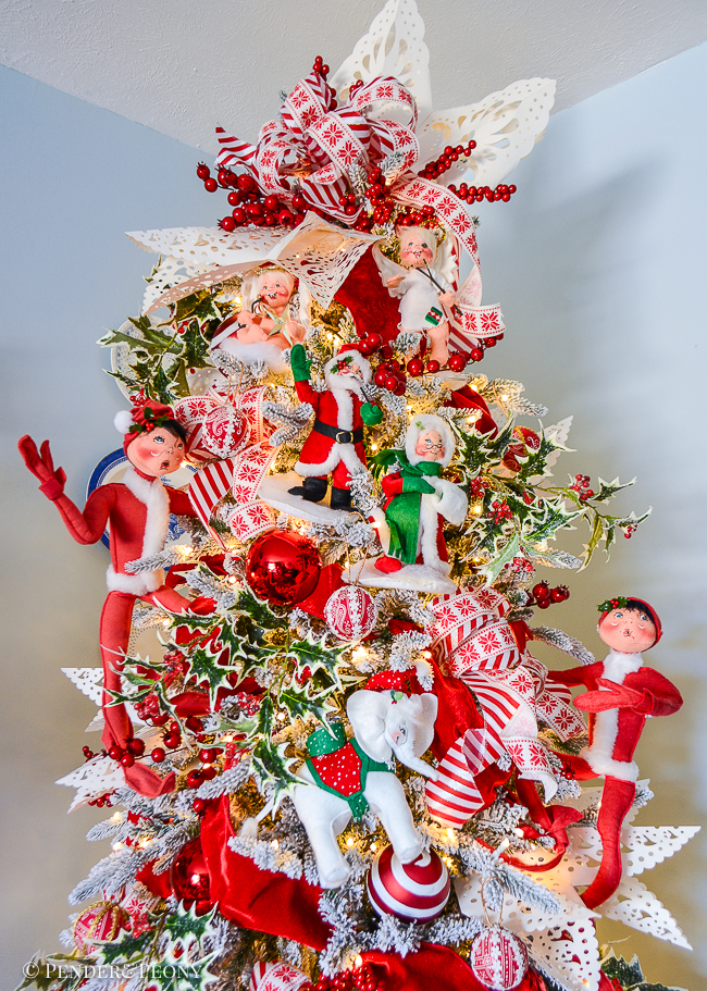 A view of the top of my red and white Christmas tree decorated with Annalee elves, Santas, and animals, white snowflakes, and candy cane striped ribbons