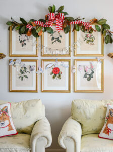12 Days of Christmas banner hung on camellia prints with magnolia garland above